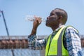 Engineer Man Drinking Water at Site, Construction Worker Staying Hydrated on Site, Man Drinking Water Outdoors on Hot Day Royalty Free Stock Photo