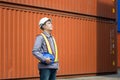 Engineer man in shipping container yard, Foreman dock worker in hard hat at industry containers cargo Royalty Free Stock Photo