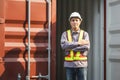 Engineer man standing with arms crossed at cargo containers, Foreman dock worker in hard hat at shipping container yar Royalty Free Stock Photo