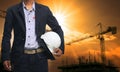 Engineer man standing with white safety helmet against beautiful Royalty Free Stock Photo