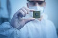 Engineer man in sterile suit is holding Microchip with symbols in modern design factory , futuristic and artificial intelligence