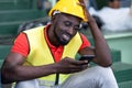 Engineer man wearing a safety helmet, vest sitting in the automotive parts warehouse factory. Industrial worker Looking at