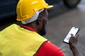 Engineer man wearing a safety helmet, vest sitting in the automotive parts warehouse factory. Industrial worker Looking at