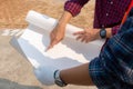 Engineer man and worker checking and planning project at construction site, Man looking into the blueprint over blurred background Royalty Free Stock Photo