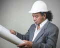 Engineer man worker with white safety uniform helmet  holding a drawing blueprint paper plan, construction process layout. Royalty Free Stock Photo