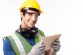 Engineer man working on digital tablet computer at worksite. Handsome young industrial worker wear hardhat, safety glove, safety