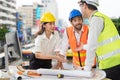 Engineer mixed race caucasian man and asian woman wear hard hat discussing about building plan on computer for construction at job Royalty Free Stock Photo