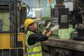 Engineer with monitor checking quality result of work. Man technician is working in a steel factory. Man worker in safety helmet Royalty Free Stock Photo