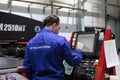 An engineer at the monitor of a numerically controlled machine controls the process of manufacturing metal substrates Royalty Free Stock Photo