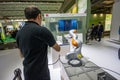 Engineer operates industrial KUKA robot in booth of Huawei company