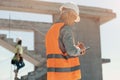 An engineer in an orange vest and white construction control