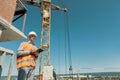 An engineer in an orange vest and a white construction control helmet conduct Royalty Free Stock Photo