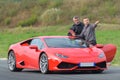 Engineer and pilot talking race strategy near lamborghini supercar Royalty Free Stock Photo