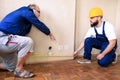 Engineer and project manager with his colleague, construction worker is measuring wall room for renovation using measure tape. Royalty Free Stock Photo