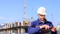 Engineer protective helmet stand in front of blue sky background. Contractor control according to plan. Builder engineer