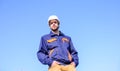 Engineer protective helmet stand in front of blue sky background. Foreman control construction process. Contractor Royalty Free Stock Photo