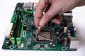 Engineer repairman holding hands in black gloves chip processor, CPU to insert into the socket of the computer motherboard. The Royalty Free Stock Photo