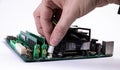 Engineer repairman holding hands in black gloves chip processor, CPU to insert into the socket of the computer motherboard. The Royalty Free Stock Photo