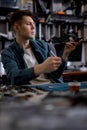 Engineer restores the laptop PC, examining disassembled parts of laptop. Electronic repair shop