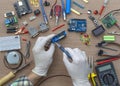 An engineer\'s hands are assembling a breadboard from an Arduino microcontroller