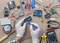 An engineer\'s hands are assembling a breadboard from an Arduino microcontroller,