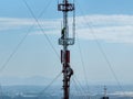 Engineer with safety equipment on high tower for working telecom communication maintenance.