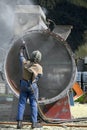 Engineer sandblasting a steel casing