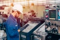 Engineer setup the CNC machine with G-Code programming upload from Computer Tablet for technology in heavy industry