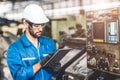 Engineer setup the CNC machine with G-Code programming upload from Computer Tablet for technology in heavy industry