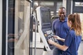 Engineer Showing Apprentice How To Use CNC Tool Making Machine