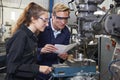 Engineer Showing Apprentice How to Use Drill In Factory Royalty Free Stock Photo