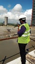 An Engineer is signaling operator of concrete pump through walkie talkie at the time concreting at a construction site.