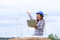 Engineer sits at his laptop looking at a clean energy wind turbine project to generate electricity