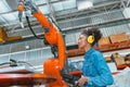 Engineer smart woman worker working programing robotic welding machine. Black teen girl work in advance modern factory