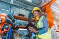 Engineer smart woman worker working programing robotic welding machine. Black teen girl work in advance modern factory Royalty Free Stock Photo