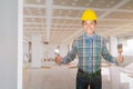 Engineer smile with hand holding Triangle trowel and paint brush wear yellow safety helmet plastic in building construction