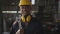 Engineer standing holding wrench on his shoulder at work in industry Royalty Free Stock Photo