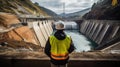 An engineer stands in front of a dam Royalty Free Stock Photo