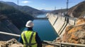An engineer stands in front of a dam Royalty Free Stock Photo