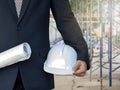 Engineer in suit with blueprint and helmet in construction site Royalty Free Stock Photo