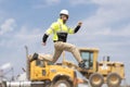 Engineer supervisor running outdoor. Supervisor jumping. Excited construction builder. Worker jumping at heavy machines. Man Royalty Free Stock Photo