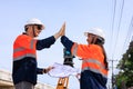 engineer and surveyor engineers high five after work at road construction site, angle shot Royalty Free Stock Photo