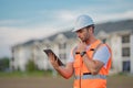 Engineer with tablet, building inspection. Caucasian man, construction worker in helmet at construction site. Engineer Royalty Free Stock Photo