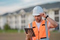 Engineer with tablet, building inspection. Construction man in helmet build new house. Engineer work in builder uniform Royalty Free Stock Photo