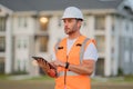 Engineer with tablet, building inspection. Construction man in helmet build new house. Engineer work in builder uniform Royalty Free Stock Photo