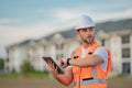 Engineer with tablet, building inspection. Construction man in helmet build new house. Engineer work in builder uniform Royalty Free Stock Photo