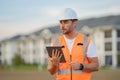 Engineer with tablet, building inspection. Portrait of builder in a construction site. Builder ready to build new house Royalty Free Stock Photo
