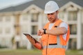 Engineer with tablet, building inspection. Serious engineer at new home. Construction manager in helmet. Architect at a Royalty Free Stock Photo