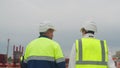 Engineer and taskmaster walk along construction site