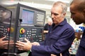 Engineer Teaching Apprentice To Use Computerized Lathe Royalty Free Stock Photo